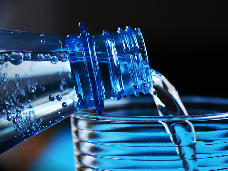 Mineralwasser-Plastikflasche-Glas-einschenken
